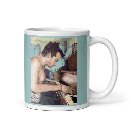 A coffee mug featuring a painting of a man playing the piano, called Ivory Keys, on an 11oz mug.