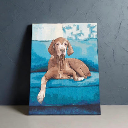 Canvas art of a cute vizsla dog sitting on a blue couch, artwork leaning against a dark blue background.